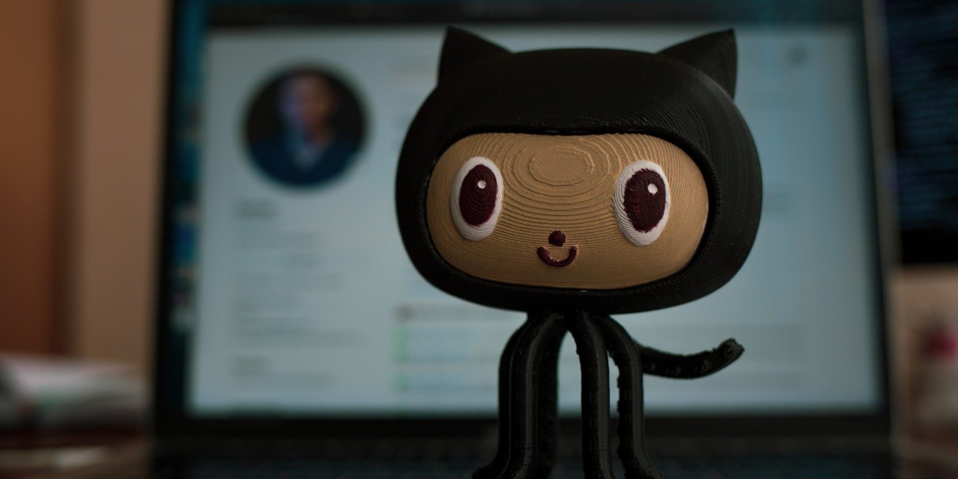 A photograph of the Github mascot in front of the Github webpage.